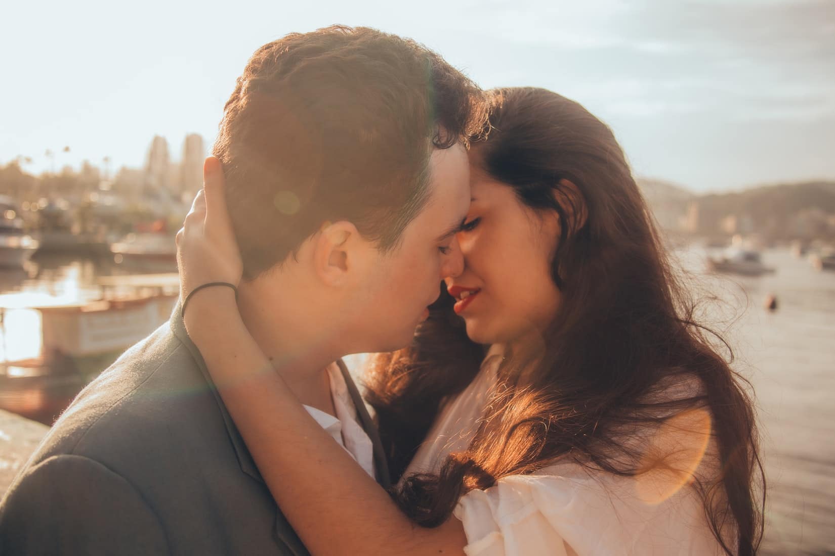 Guy kissing a girl as the sun sets.