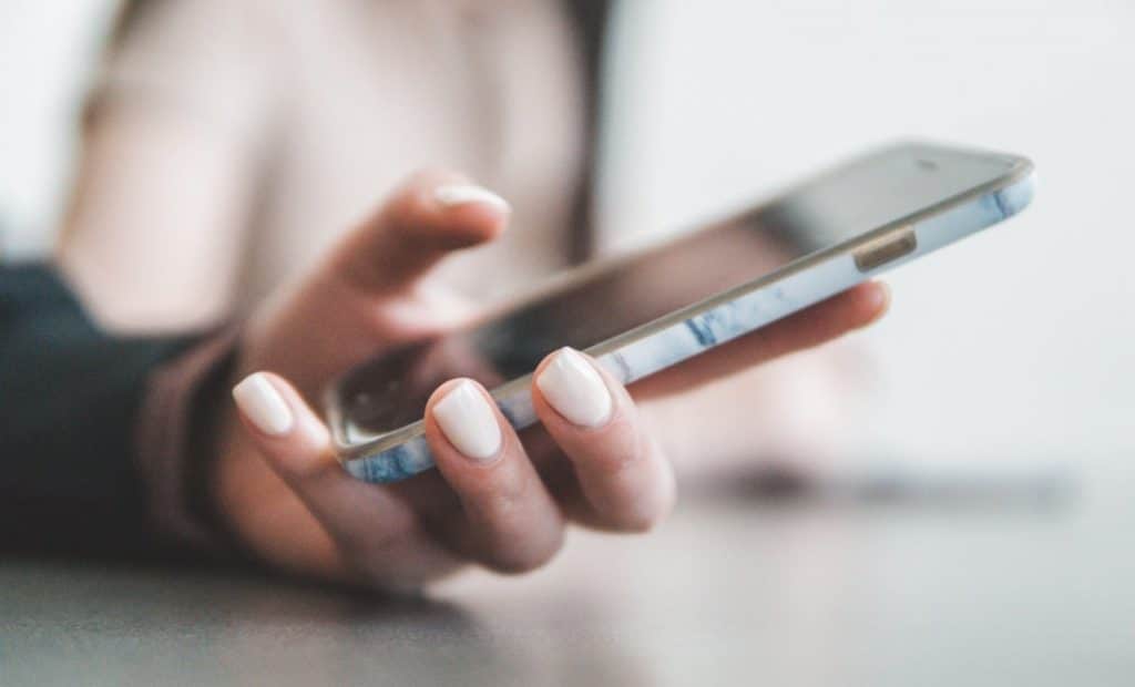 Girl holding her phone texting.