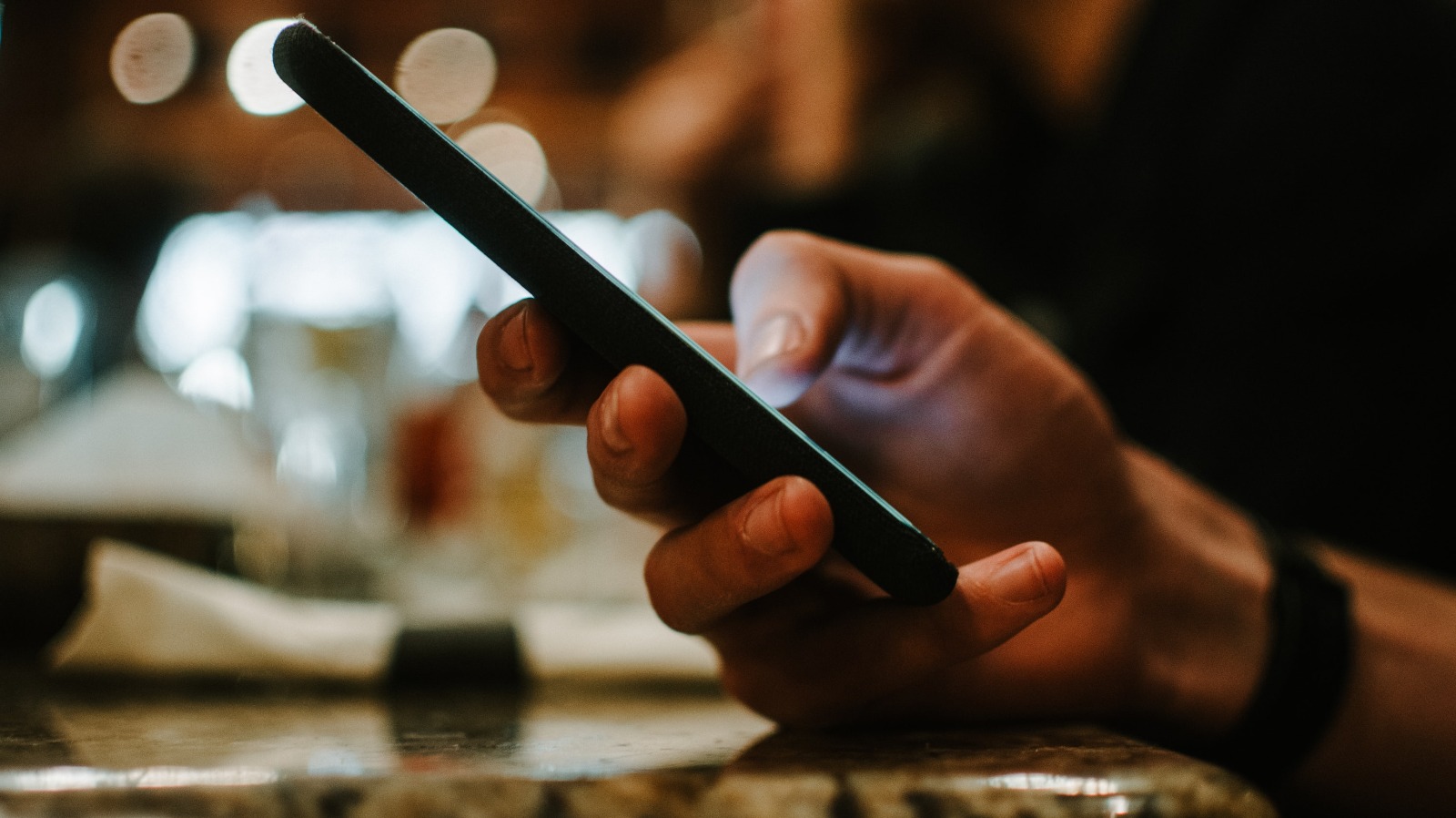 Photo of a guy holding a phone and texting