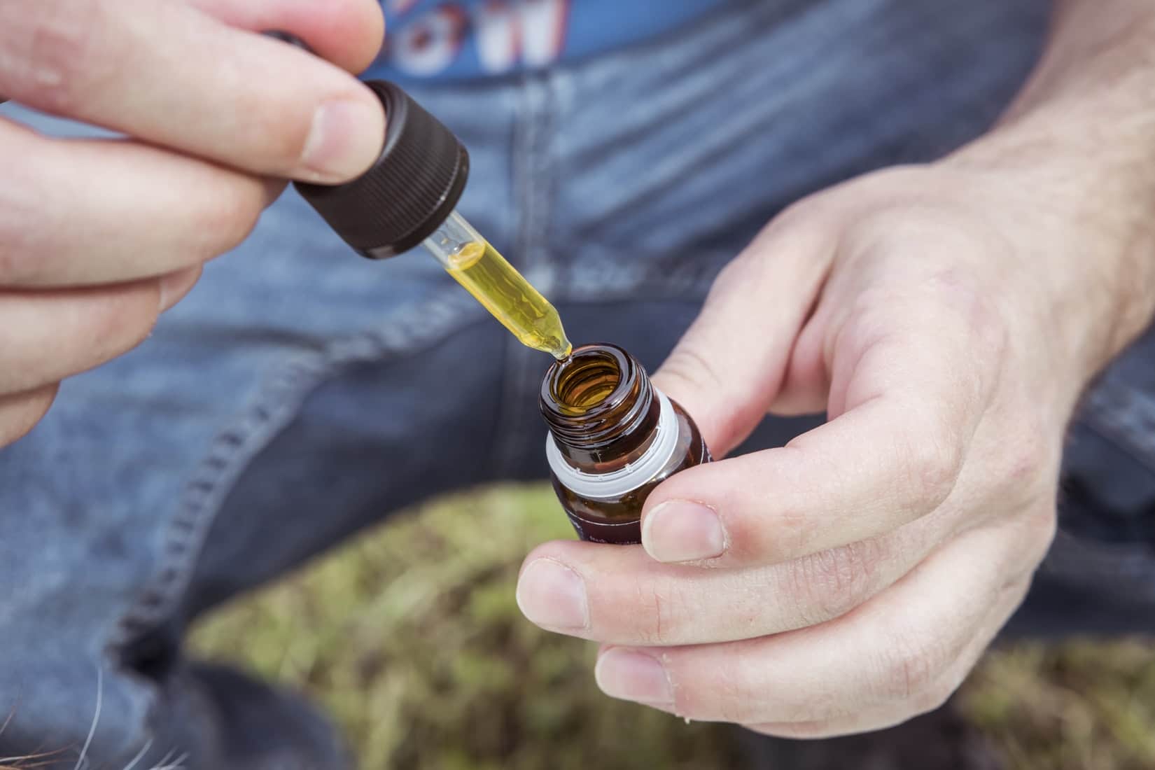 Man using a CBD oil with a tincture.